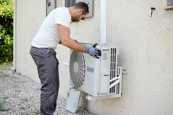 tech repairing an air conditioner