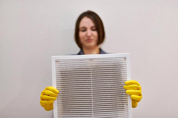 Homeowner looking at dirty air filter